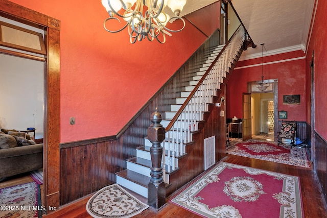 627 Emmett St, Palatka, FL 32177 - stairway with a chandelier, hardwood / wood-style flooring, visible vents, and a wainscoted wall