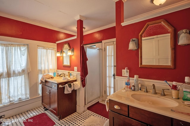 627 Emmett St, Palatka, FL 32177 - bathroom with two vanities, ornamental molding, a wainscoted wall, a sink, and a stall shower