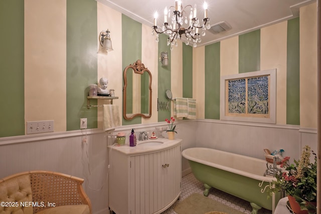 627 Emmett St, Palatka, FL 32177 - bathroom featuring a chandelier, a freestanding tub, vanity, and a wainscoted wall