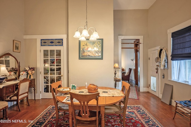 627 Emmett St, Palatka, FL 32177 - dining space featuring wood finished floors, an inviting chandelier, and a towering ceiling