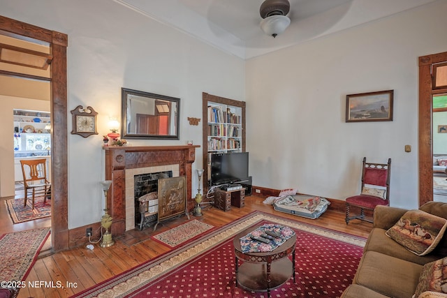 627 Emmett St, Palatka, FL 32177 - living area featuring a tiled fireplace, ceiling fan, wood finished floors, and baseboards