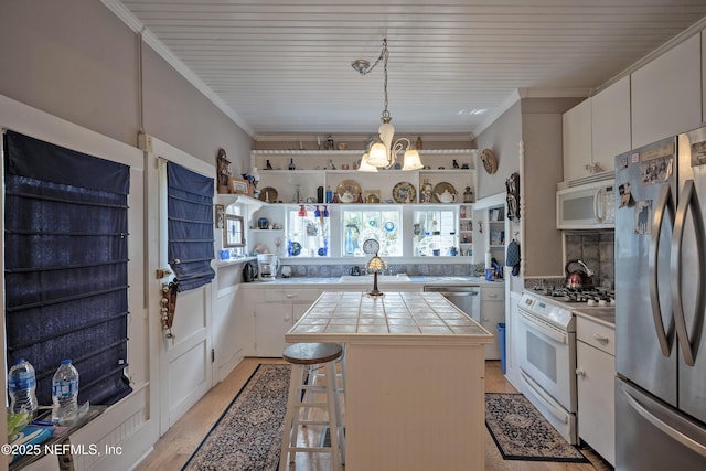 627 Emmett St, Palatka, FL 32177 - kitchen featuring crown molding, tile counters, a center island, and appliances with stainless steel finishes