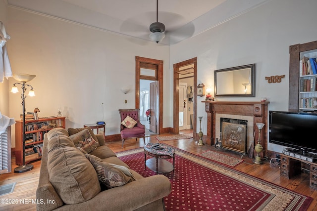627 Emmett St, Palatka, FL 32177 - living room featuring visible vents, baseboards, ceiling fan, hardwood / wood-style flooring, and a tile fireplace