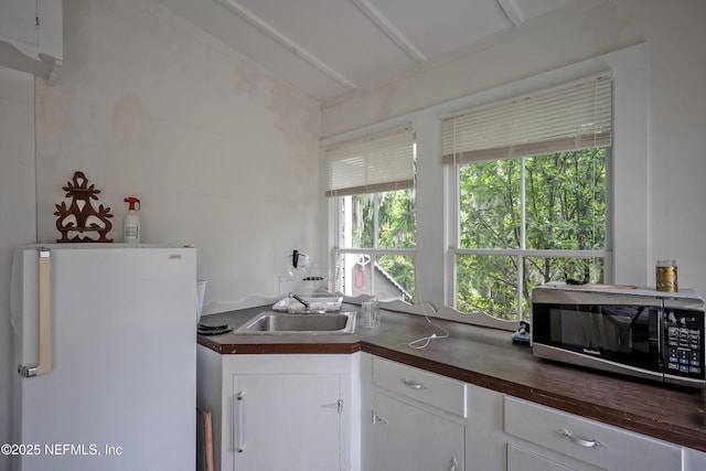 627 Emmett St, Palatka, FL 32177 - kitchen featuring white cabinets, a sink, freestanding refrigerator, stainless steel microwave, and butcher block countertops