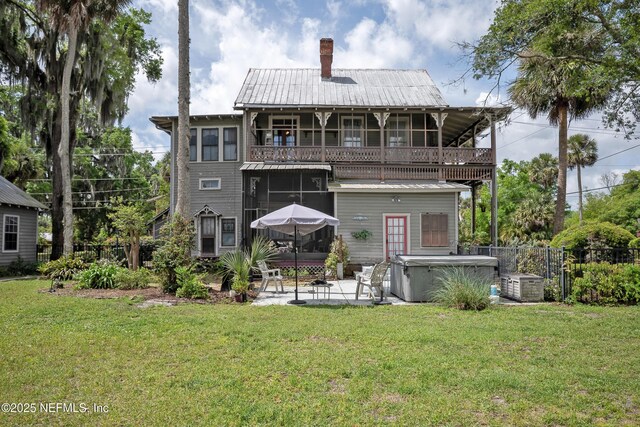 627 Emmett St, Palatka, FL 32177 - back of property with a sunroom, a lawn, a patio area, metal roof, and a balcony