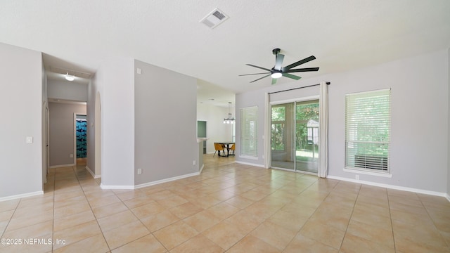 unfurnished room with light tile patterned flooring, visible vents, baseboards, and ceiling fan