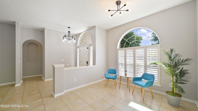 unfurnished room featuring baseboards, tile patterned flooring, and a notable chandelier