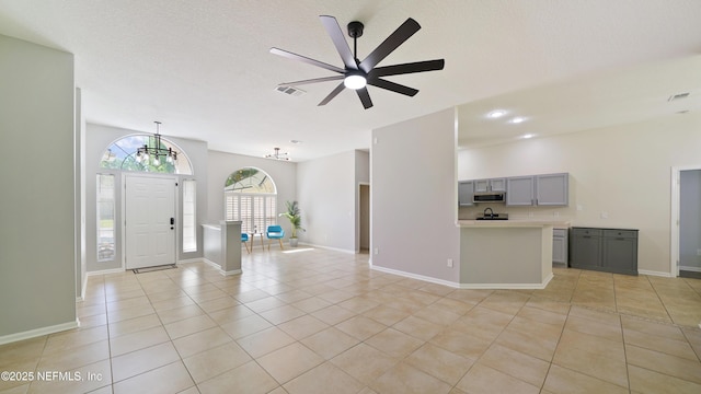 interior space featuring ceiling fan, baseboards, light tile patterned flooring, and visible vents