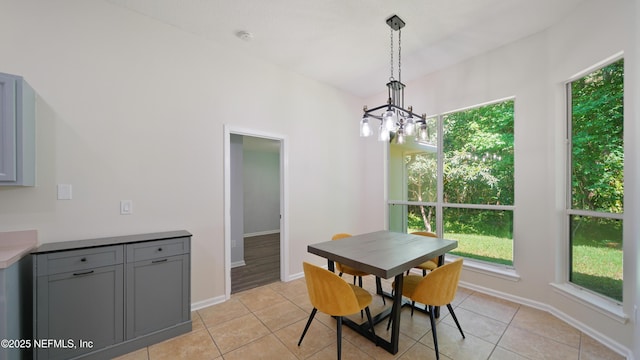 dining area with a healthy amount of sunlight, a chandelier, and light tile patterned floors