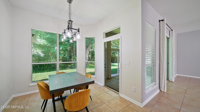 dining room with a chandelier, baseboards, and light tile patterned floors