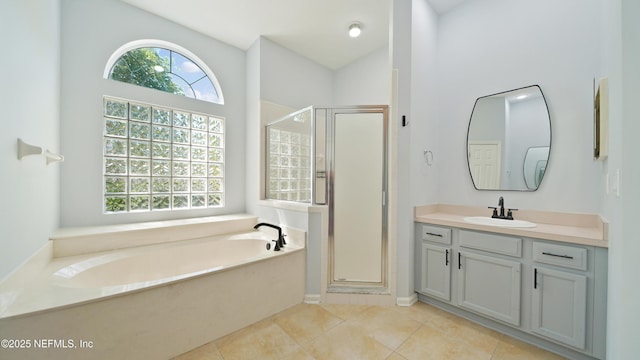 full bathroom featuring tile patterned floors, a garden tub, vanity, and a stall shower
