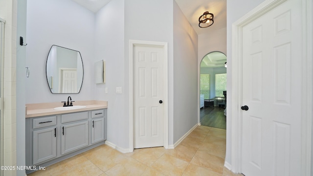 full bath with baseboards, a ceiling fan, vanity, and tile patterned floors