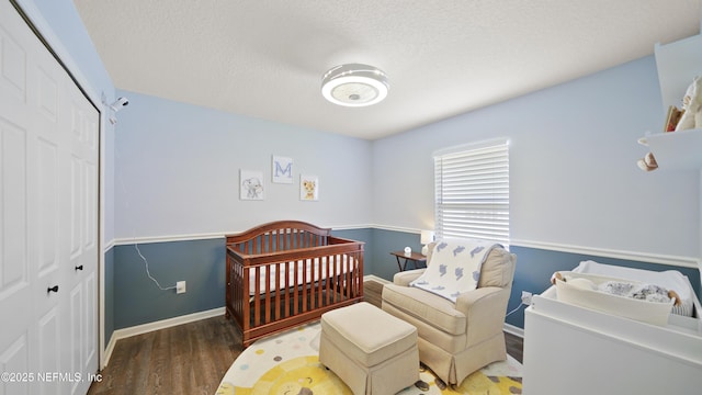 bedroom featuring baseboards, wood finished floors, a textured ceiling, and a closet
