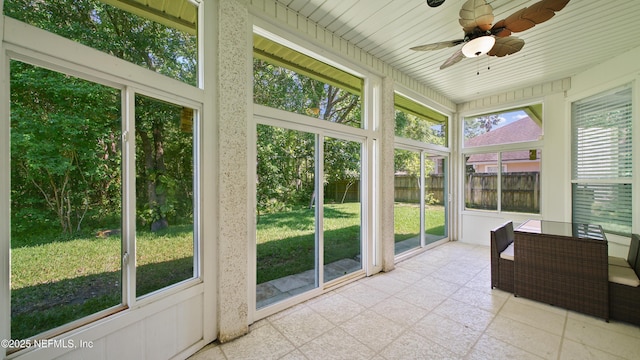 unfurnished sunroom featuring a ceiling fan