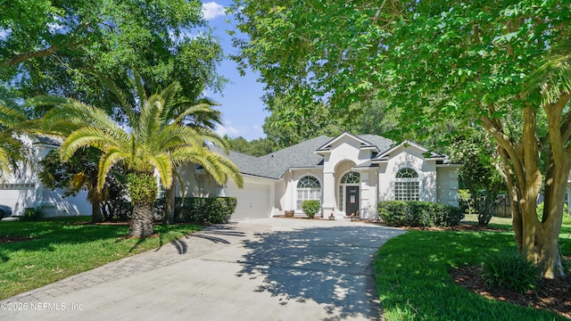 single story home with stucco siding, an attached garage, concrete driveway, and a front yard