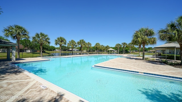 community pool featuring fence, a gazebo, and a patio