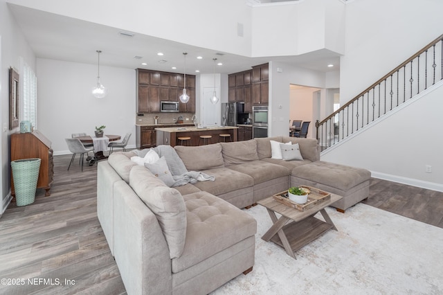 184 Rockcreek Dr, Saint Johns, FL 32259 - living room featuring wood finished floors, baseboards, recessed lighting, stairway, and a towering ceiling