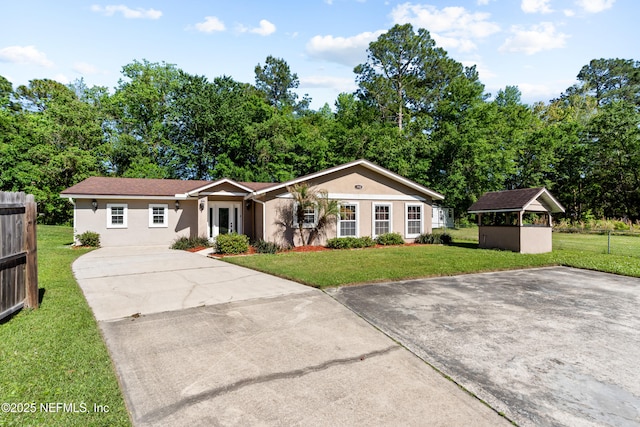 ranch-style house with driveway, stucco siding, fence, and a front lawn