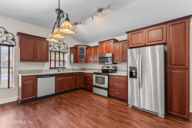 kitchen with light countertops, a healthy amount of sunlight, vaulted ceiling, and stainless steel appliances