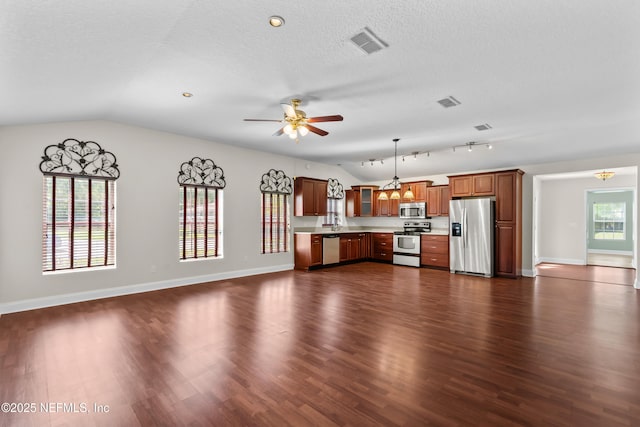 kitchen with visible vents, light countertops, stainless steel appliances, dark wood-type flooring, and lofted ceiling
