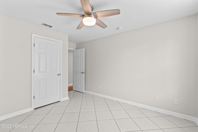 unfurnished bedroom with light tile patterned floors, visible vents, baseboards, and ceiling fan