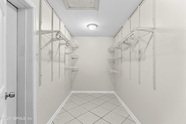 walk in closet with light tile patterned floors