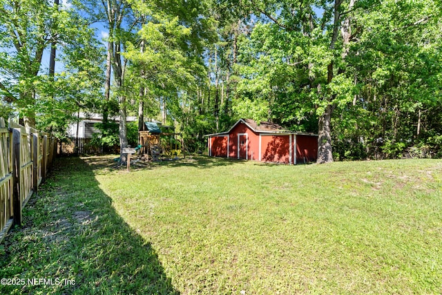 view of yard featuring an outbuilding, fence, and a playground