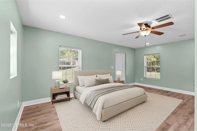 bedroom featuring visible vents, baseboards, and wood finished floors
