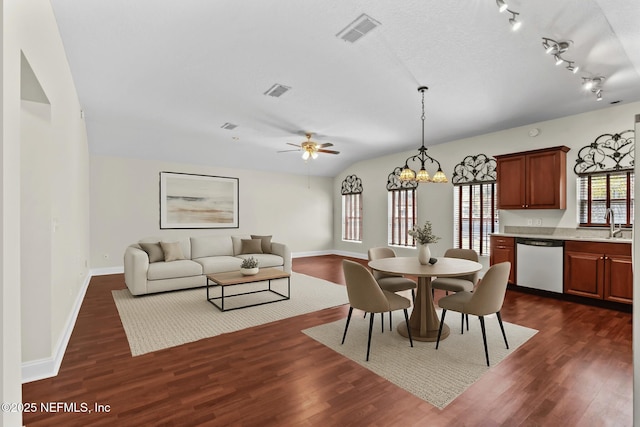 dining space with ceiling fan with notable chandelier, dark wood-style flooring, baseboards, and visible vents