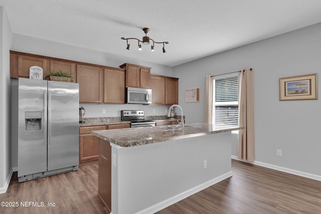 3699 Summit Oaks Dr, Green Cove Springs, FL 32043 - kitchen with a sink, appliances with stainless steel finishes, a chandelier, brown cabinetry, and wood finished floors