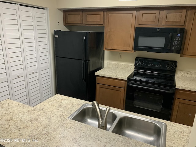 5473 Pinehaven Ct, Jacksonville, FL 32244 - kitchen with a sink, light countertops, black appliances, and brown cabinets