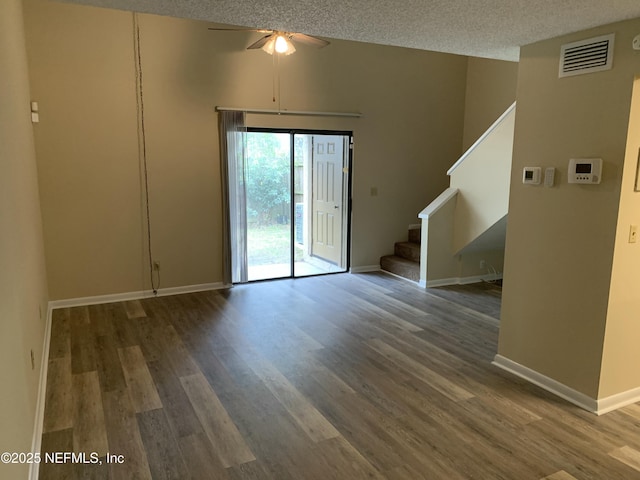 5473 Pinehaven Ct, Jacksonville, FL 32244 - unfurnished living room featuring visible vents, a ceiling fan, a textured ceiling, wood finished floors, and stairs