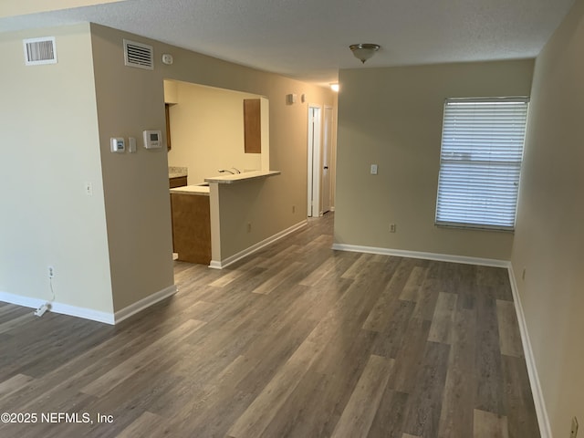 5473 Pinehaven Ct, Jacksonville, FL 32244 - unfurnished living room with visible vents, baseboards, a textured ceiling, and dark wood finished floors