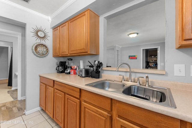 1648 Rhonda Dr, Middleburg, FL 32068 - kitchen featuring baseboards, ornamental molding, light countertops, light tile patterned flooring, and a sink