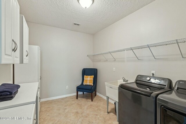 244 W Berkswell Dr, Saint Johns, FL 32259 - laundry area featuring a textured ceiling, visible vents, baseboards, cabinet space, and washer and clothes dryer