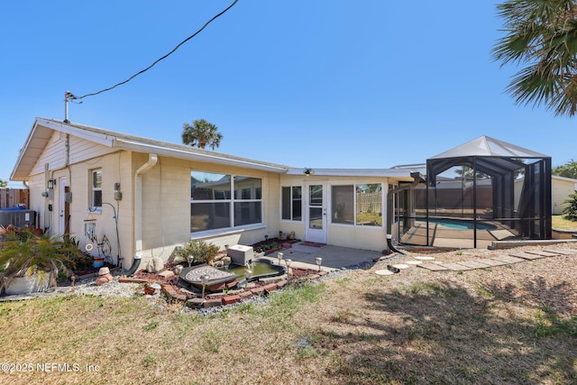 16 San Jose Cir, Ormond Beach, FL 32176 - rear view of property with concrete block siding, a fenced in pool, cooling unit, a patio area, and glass enclosure