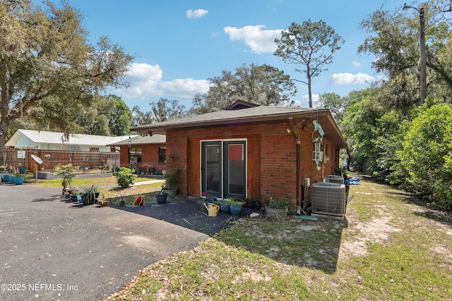 5822 Silver Sands Cir, Keystone Heights, FL 32656 - back of house with brick siding, central AC, and fence