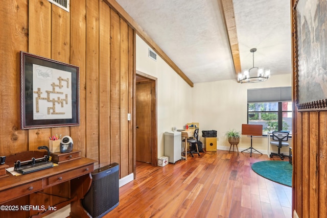 5822 Silver Sands Cir, Keystone Heights, FL 32656 - interior space with visible vents, a chandelier, wood walls, baseboards, and hardwood / wood-style flooring