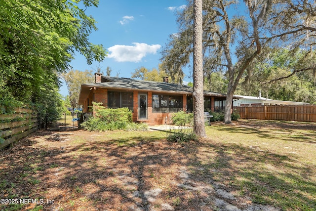 5822 Silver Sands Cir, Keystone Heights, FL 32656 - rear view of house featuring a chimney, a gate, fence, and brick siding