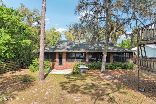 5822 Silver Sands Cir, Keystone Heights, FL 32656 - rear view of house with a sunroom, entry steps, fence, and brick siding