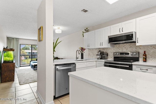 kitchen featuring tasteful backsplash, a sink, white cabinets, and stainless steel appliances