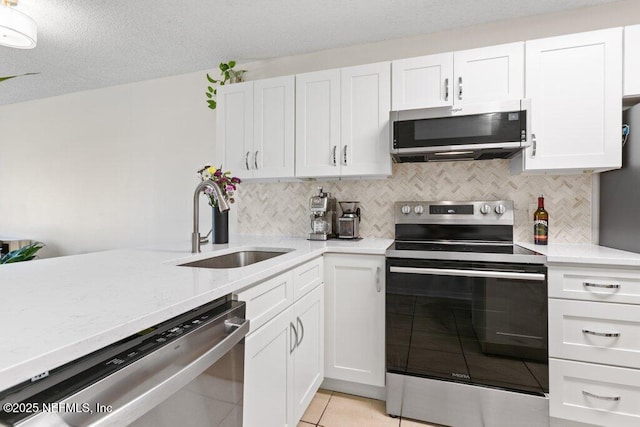 kitchen featuring decorative backsplash, a sink, white cabinets, and stainless steel appliances