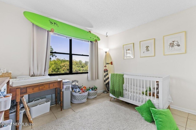tiled bedroom with baseboards and a textured ceiling