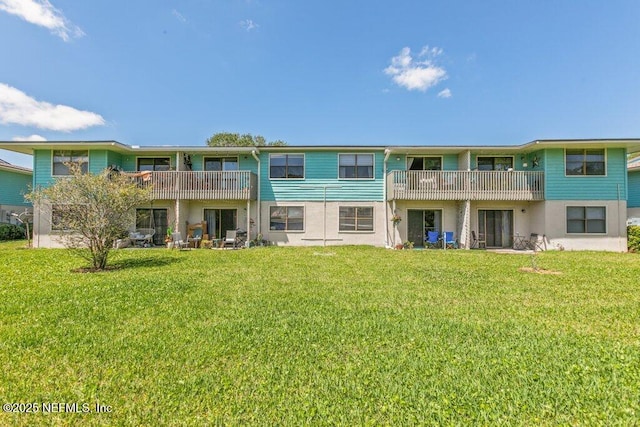 back of property featuring a yard and stucco siding