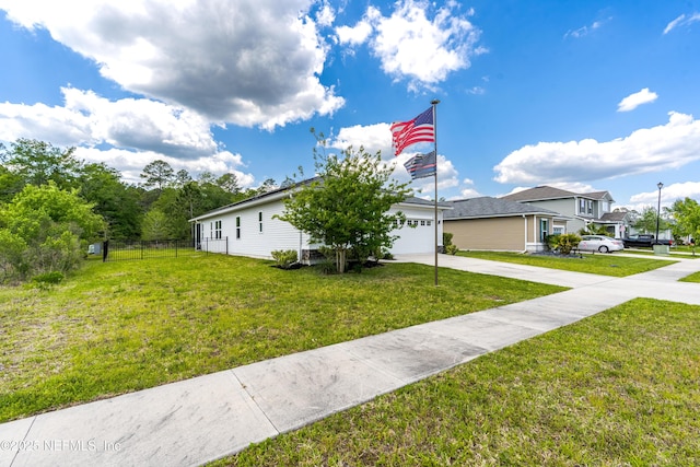 view of front of home with concrete driveway, fence, and a front lawn