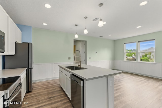 kitchen featuring light wood-style flooring, visible vents, a wainscoted wall, appliances with stainless steel finishes, and a sink