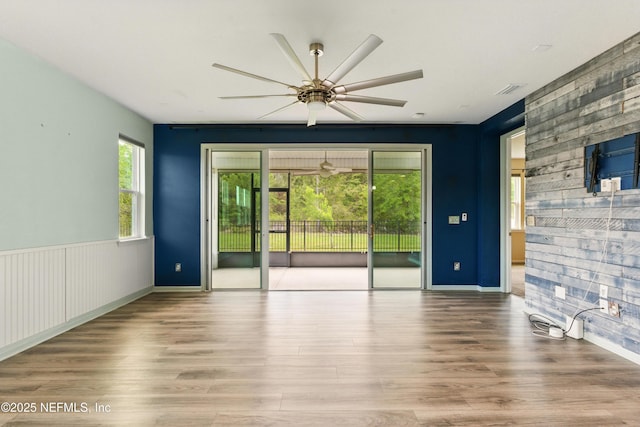 empty room featuring visible vents, wood finished floors, and ceiling fan