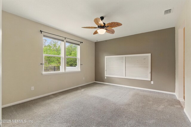 spare room with visible vents, ceiling fan, carpet, and baseboards