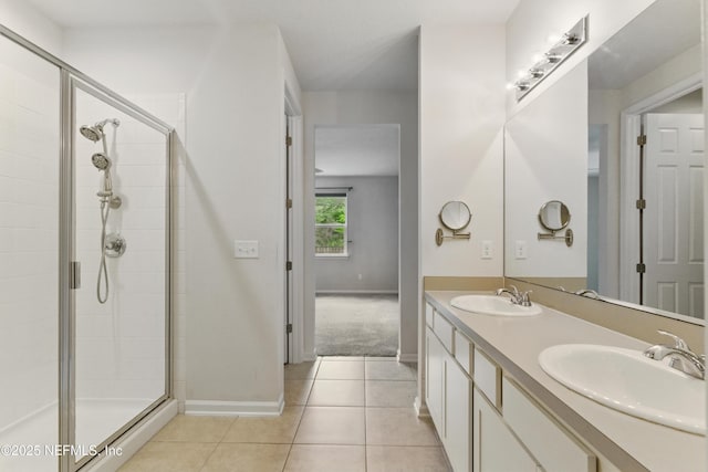 bathroom featuring a sink, a shower stall, tile patterned flooring, and double vanity