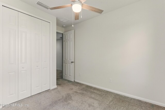 unfurnished bedroom with ceiling fan, carpet, a closet, visible vents, and baseboards